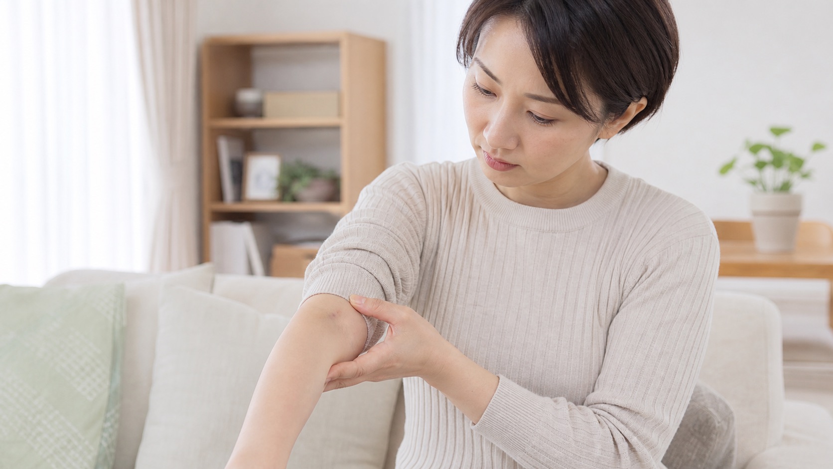 鍼を刺した場所の痛みと小さな内出血を確認する女性