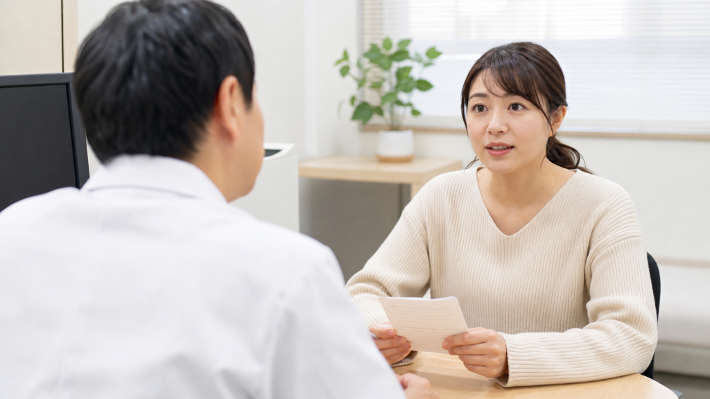 医療機関で症状とメモを相談する女性