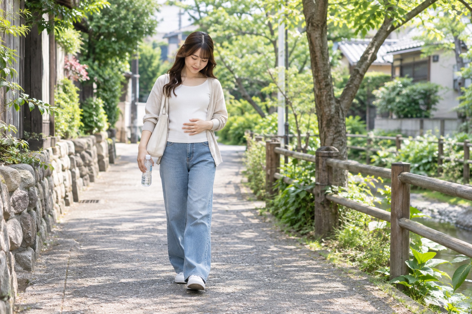 水を持ってお腹の状態を確かめながら歩く女性